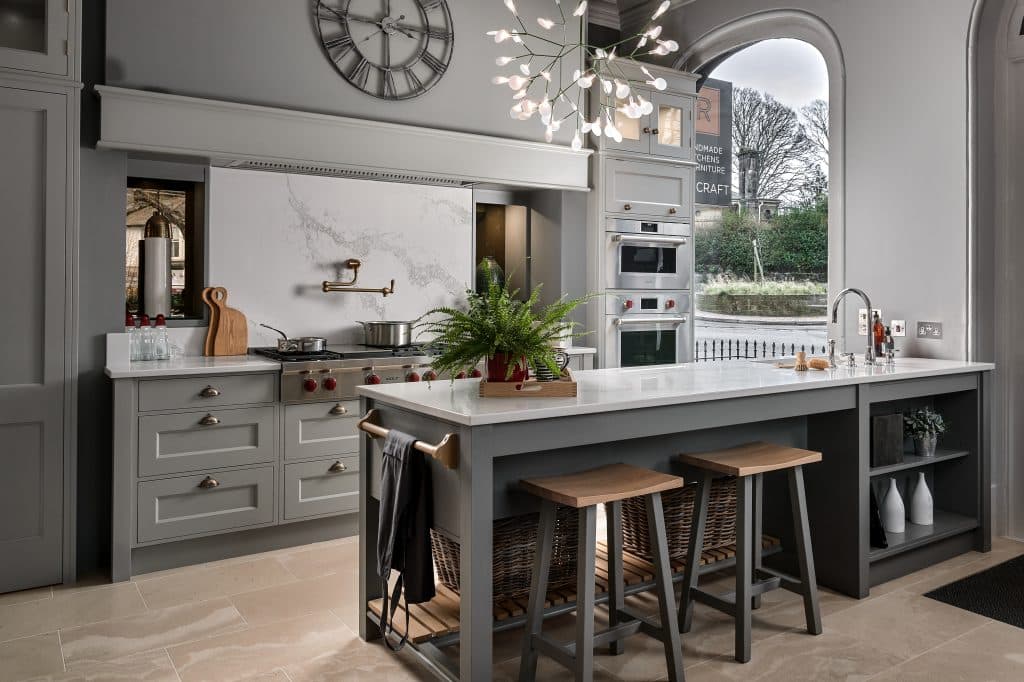 Grey painted shaker kitchen in Rencraft showroom Tunbridge Wells Kent with pot filler tap, peninsula island and SubZeroWolf appliances.