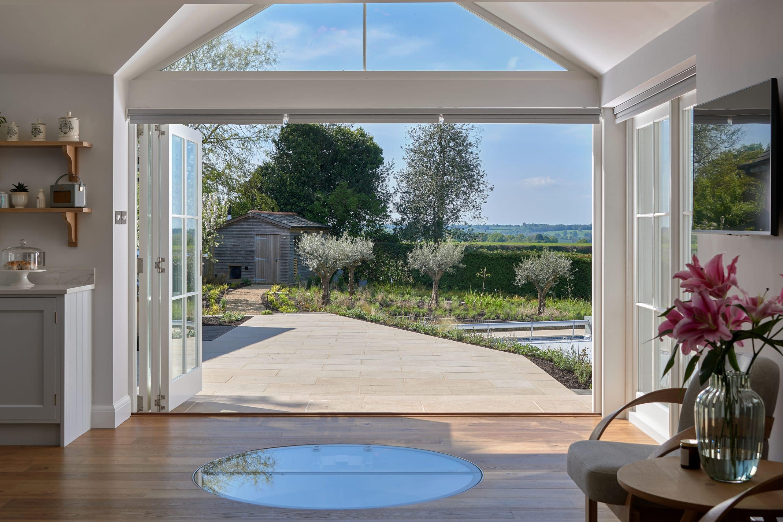 Spiral wine cellar in luxury kitchen and views to swimming pool and garden