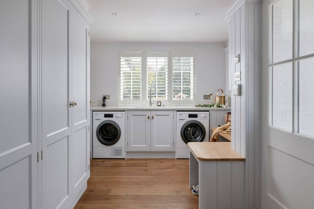 Utility room with Miele washing machine and tumbledryer and handpainted cabinetry.