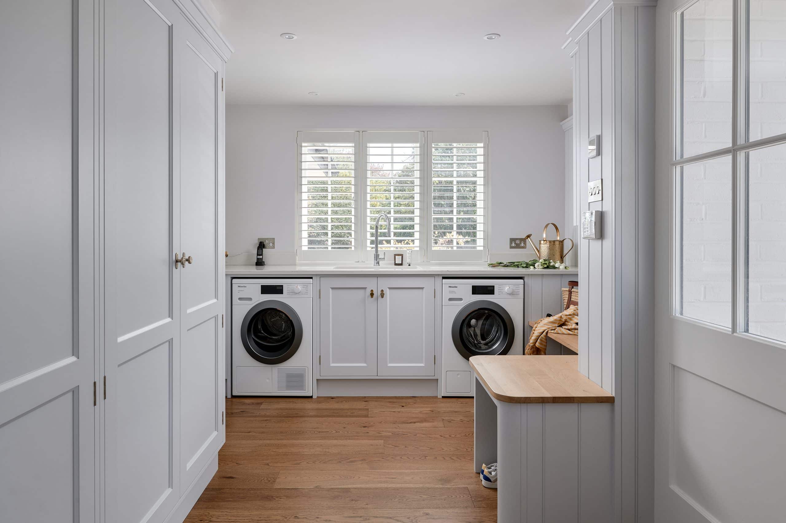 Utility room with Miele washing machine and tumbledryer and handpainted cabinetry.