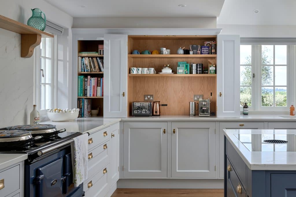 Grey painted shaker kitchen with Aga range cooker and coffee nook and Bora induction hob on a kitchen island