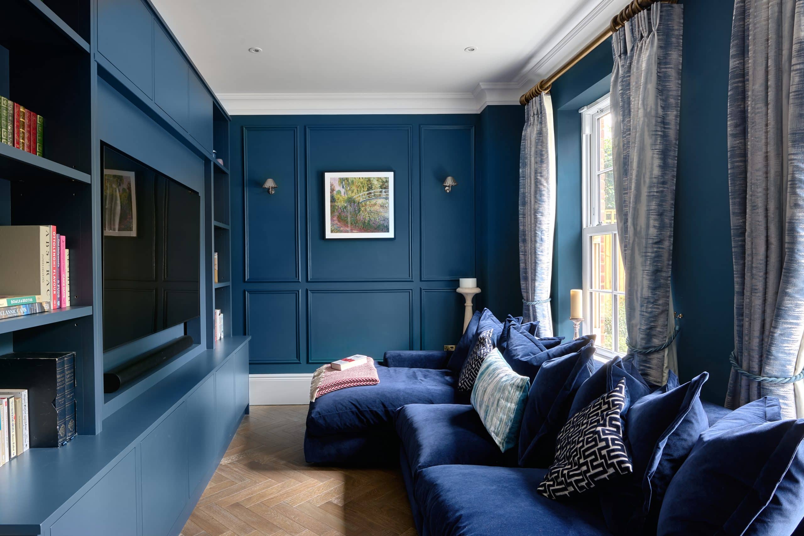 Luxury bespoke handmade TV snug with blue painted bookshelves